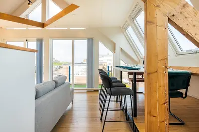 a living room with a couch and a table with chairs at Zon Modern beach house in Bergen aan Zee