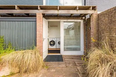 a front door of a house with a washing machine at Zon Modern beach house in Bergen aan Zee