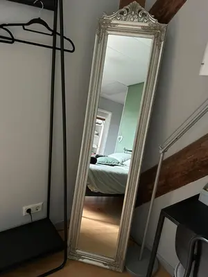 a mirror in the corner of a room with a bed at Bed en Breakfast In het Fruit in Zuidoostbeemster