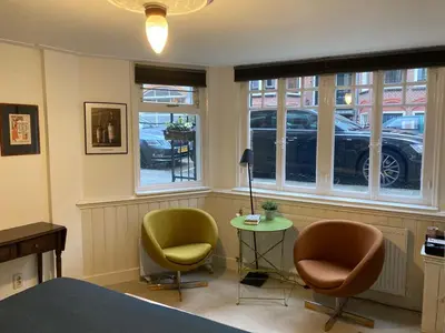 a room with two chairs and a table and windows at Obrecht Welcome in Utrecht