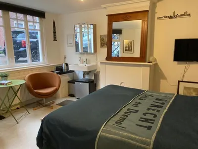 a bedroom with a bed and a sink and a mirror at Obrecht Welcome in Utrecht