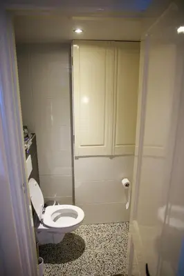 a small bathroom with a toilet and a cabinet at Obrecht Welcome in Utrecht