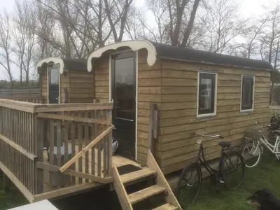a tiny house with a deck and a bike at The Cuckoo's nest in Amsterdam