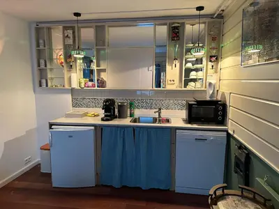 a kitchen with white cabinets and a sink at Het Kraaienest in Zaandam