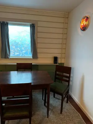 a dining room with a table and chairs and a window at Het Kraaienest in Zaandam