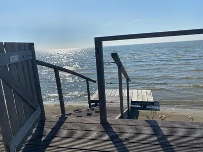a dock with a view of the beach and the ocean at Seaside in Bovenkarspel