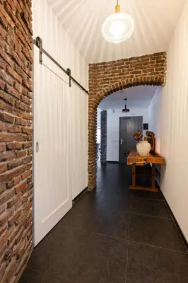 an open hallway with a brick wall and a table at Villa La Chatelaine in Egmond aan Zee