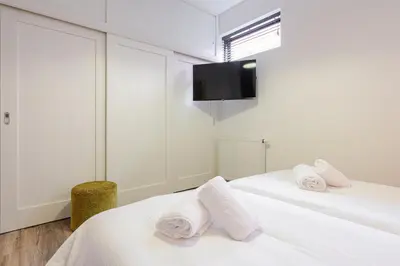 two beds in a room with two towels at Villa La Chatelaine in Egmond aan Zee