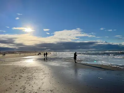 a group of people walking on the beach at Villa La Chatelaine in Egmond aan Zee