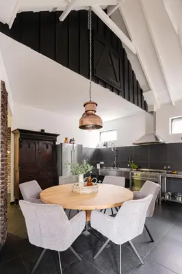 a kitchen with a wooden table and chairs at Villa La Chatelaine in Egmond aan Zee