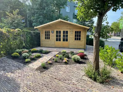 a flower garden with a dog house in the yard at Boutique B&B Dolce Due in Assendelft