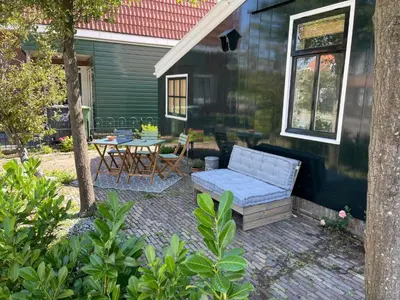 a patio with a blue couch and a table at Boutique B&B Dolce Due in Assendelft