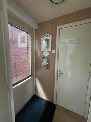 a hallway with a door and a window at Heerlijk Huisje in Bergen in Bergen