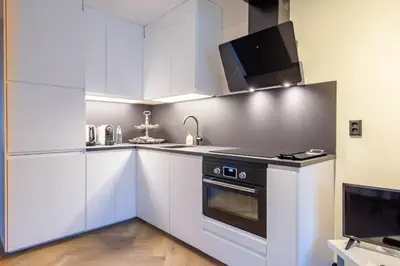 a kitchen with white cabinets and a stove top oven at Luxe Studio Liemers in Lelystad