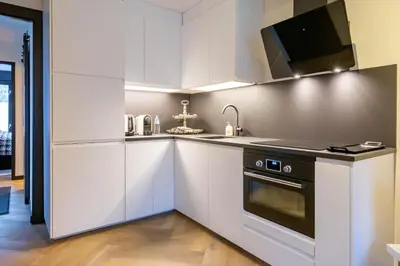 a kitchen with white cabinets and a stove top oven at Luxe Studio Liemers in Lelystad