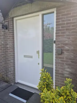 a white front door of a brick house at Luxe Studio Liemers in Lelystad