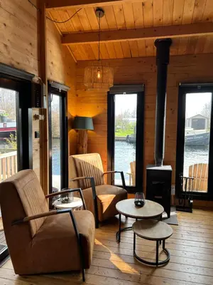 a living room with a fireplace in a log cabin at NEW - Private Cabin - on a lake near Amsterdam in Vinkeveen
