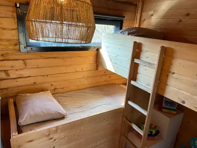 a bunk bed in a log cabin with a ladder at NEW - Private Cabin - on a lake near Amsterdam in Vinkeveen