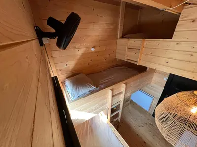 an inside view of a cabin with a bed and a table at NEW - Private Cabin - on a lake near Amsterdam in Vinkeveen