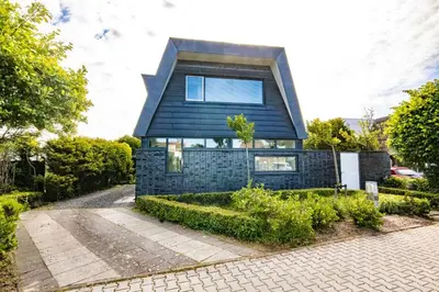 a house with a black roof at Villa Duinzand in Egmond aan den Hoef