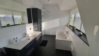 a white bathroom with two sinks and a tub at Villa Duinzand in Egmond aan den Hoef