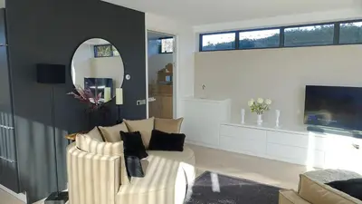 a living room with a couch and a tv at Villa Duinzand in Egmond aan den Hoef