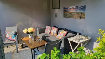 a living room with a couch and a table at Villa Duinzand in Egmond aan den Hoef