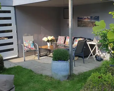 a patio with a table and chairs on a patio at Villa Duinzand in Egmond aan den Hoef