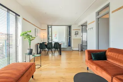 a living room with a couch and a table at Wind - Modern beach house in Bergen aan Zee
