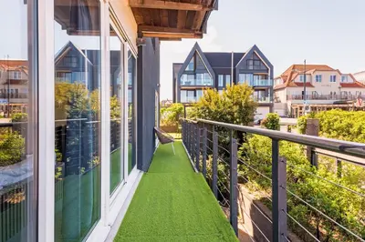 a balcony with green grass on a house at Wind - Modern beach house in Bergen aan Zee