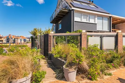 a house with plants in front of it at Wind - Modern beach house in Bergen aan Zee