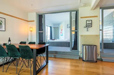 a dining room with a table and green chairs at Wind - Modern beach house in Bergen aan Zee
