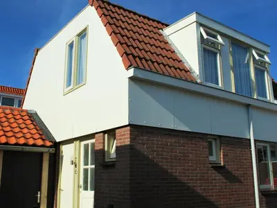 a white house with a red roof at Vakantiehuis Seahorse in Egmond aan Zee