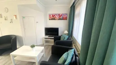 a living room with a couch and chairs and a television at Vakantiehuis Seahorse in Egmond aan Zee