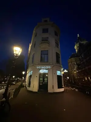 a tall building with a sign on it at night at Voyagers Amsterdam in Amsterdam
