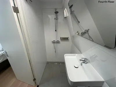 a white bathroom with a sink and a shower at Voyagers Amsterdam in Amsterdam
