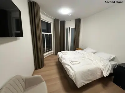 a bedroom with a white bed and a chair at Voyagers Amsterdam in Amsterdam