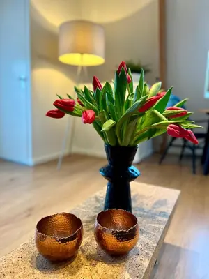 a table with a vase with a bouquet of flowers at Vakantiehuis Achter de Duinen in Castricum