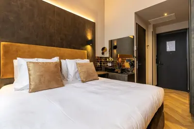 a bedroom with a large bed with white sheets and pillows at Monument Hotel in Zaandam