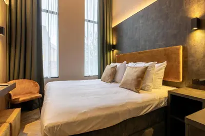 a hotel room with a bed and a chair at Monument Hotel in Zaandam