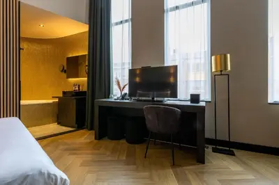 a bedroom with a desk with a chair and a bed at Monument Hotel in Zaandam