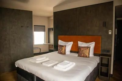 a bedroom with a large bed with towels on it at Monument Hotel in Zaandam