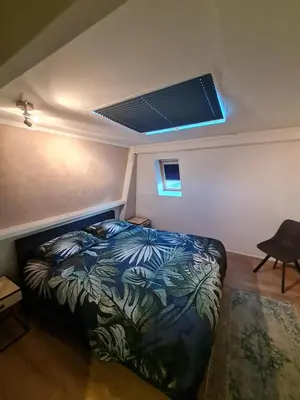 a bedroom with a bed in a room with a ceiling at Klein Middelweg in Uitgeest