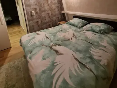 a bed with a blanket with white birds on it at Klein Middelweg in Uitgeest