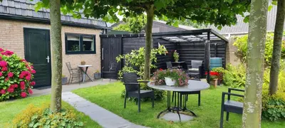 a patio with a table and chairs in a yard at Klein Middelweg in Uitgeest