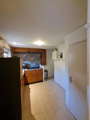 a small kitchen with a counter and a refrigerator at Klein Middelweg in Uitgeest