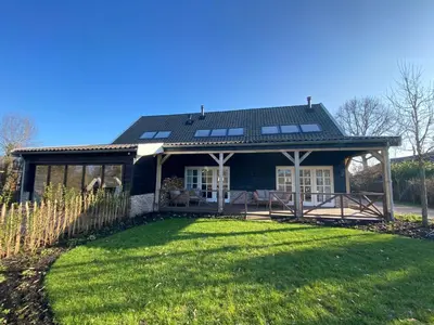 a house with a large yard in front of it at B&B De Porrel in Polsbroek