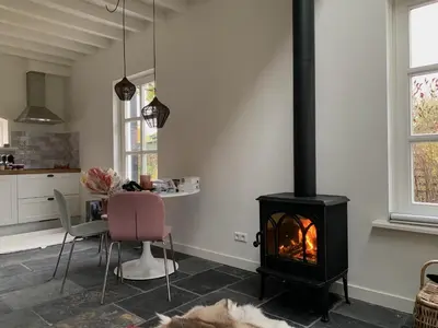 a kitchen and dining room with a stove in a room at B&B De Porrel in Polsbroek