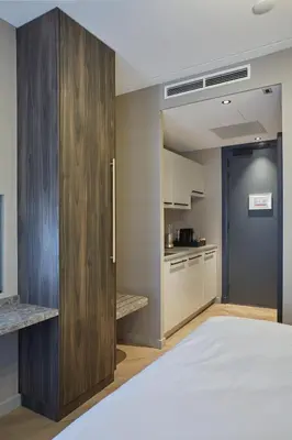a bedroom with a large wooden cabinet next to a kitchen at Breathe Boutique Hotel in Leiden