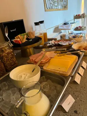a counter top with cheese and a bowl of milk at Breathe Boutique Hotel in Leiden